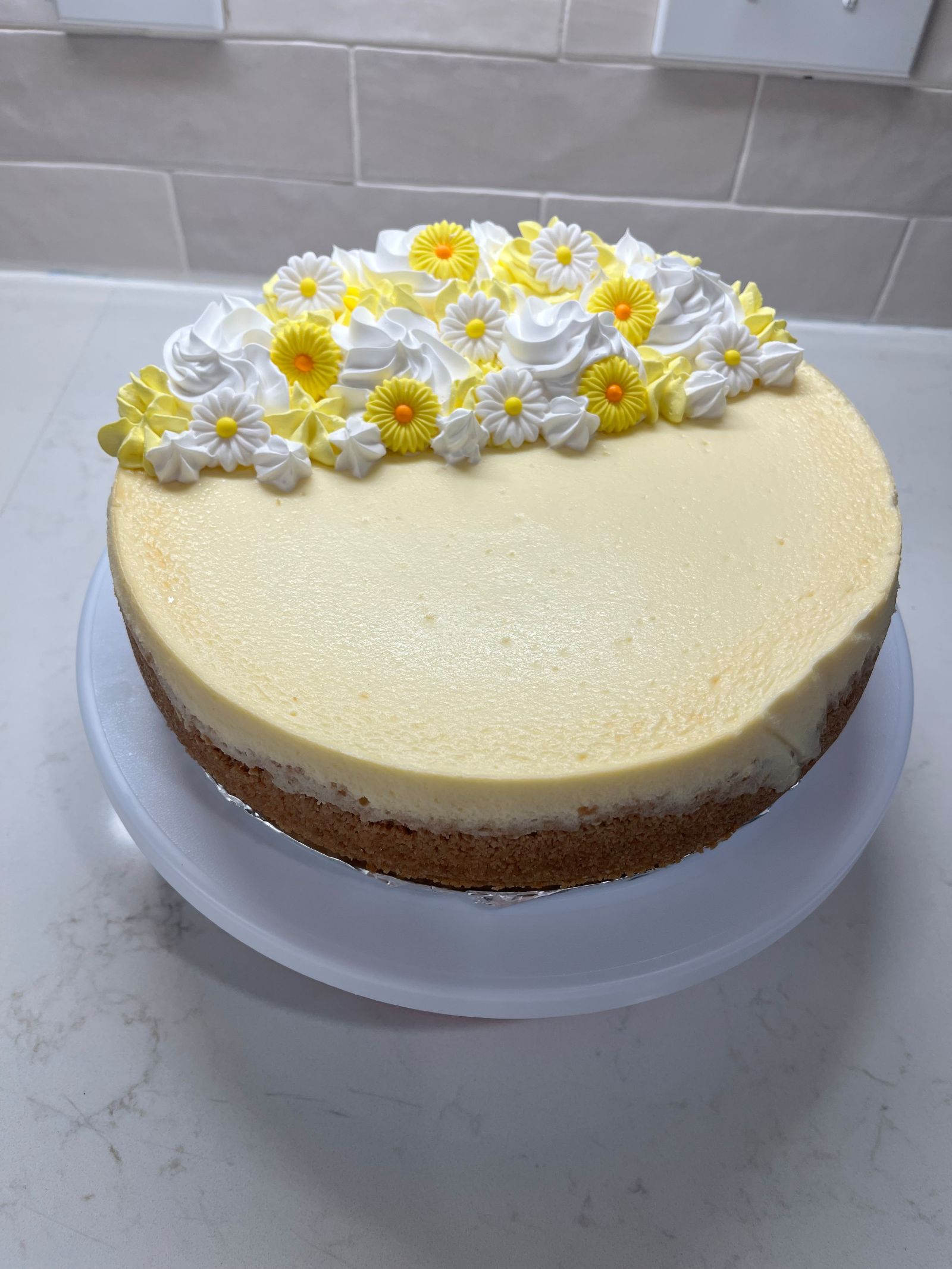 Classic cheesecake with yellow and white sugar daisies